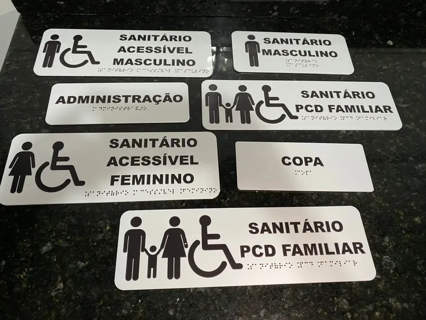 Conjunto de placas em braille e alto-relevo: sanitários, administração e copa sobre granito